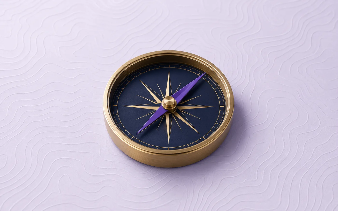 A brass compass resting on a plain surface